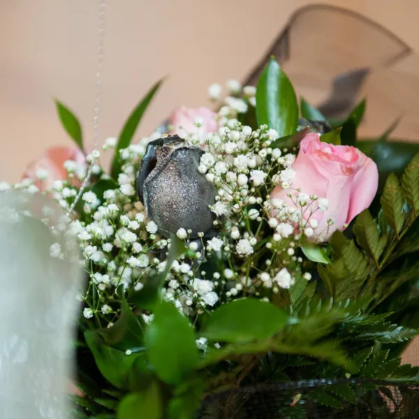 Composizione floreale con rose rosa e fiori di campo