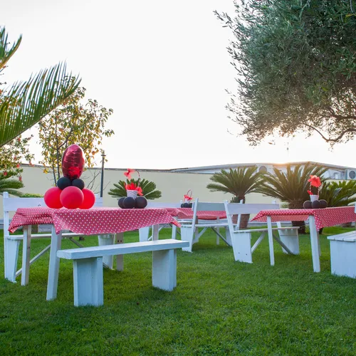 Tavoli da giardino allestiti a festa, vista dal prato