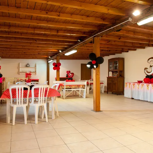Sala allestita per una festa di compleanno a tema, con decorazioni a pois rosso e nero