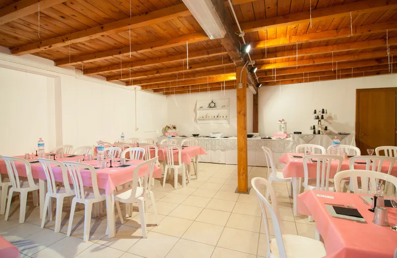 Sala vuota e pronta, con soffitto a travi di legno a vista